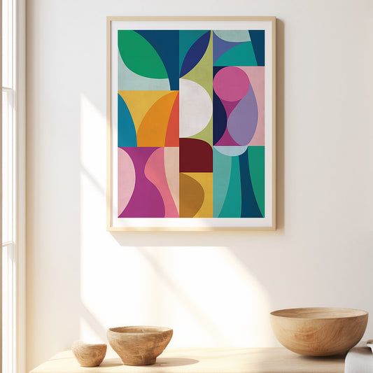 Colorful abstract art print in a wooden frame on a white wall with wooden bowls below.