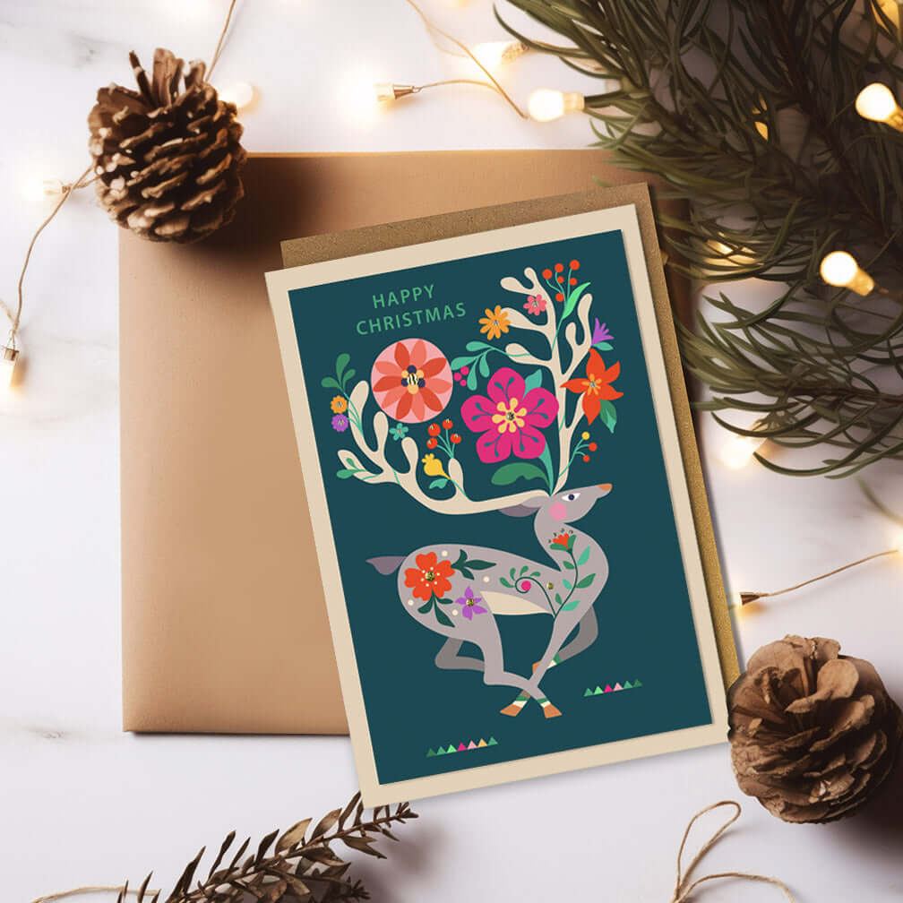 Christmas card with a graceful deer surrounded by vibrant flowers, spreading joy and festive cheer.