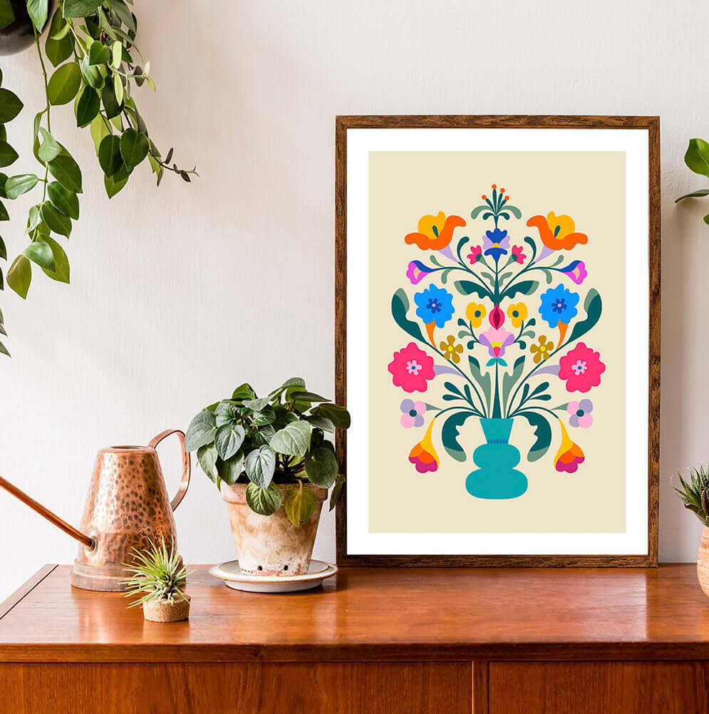 A vibrant floral wall art with a colorful flower arrangement in a frame, beautifully displayed on a table.