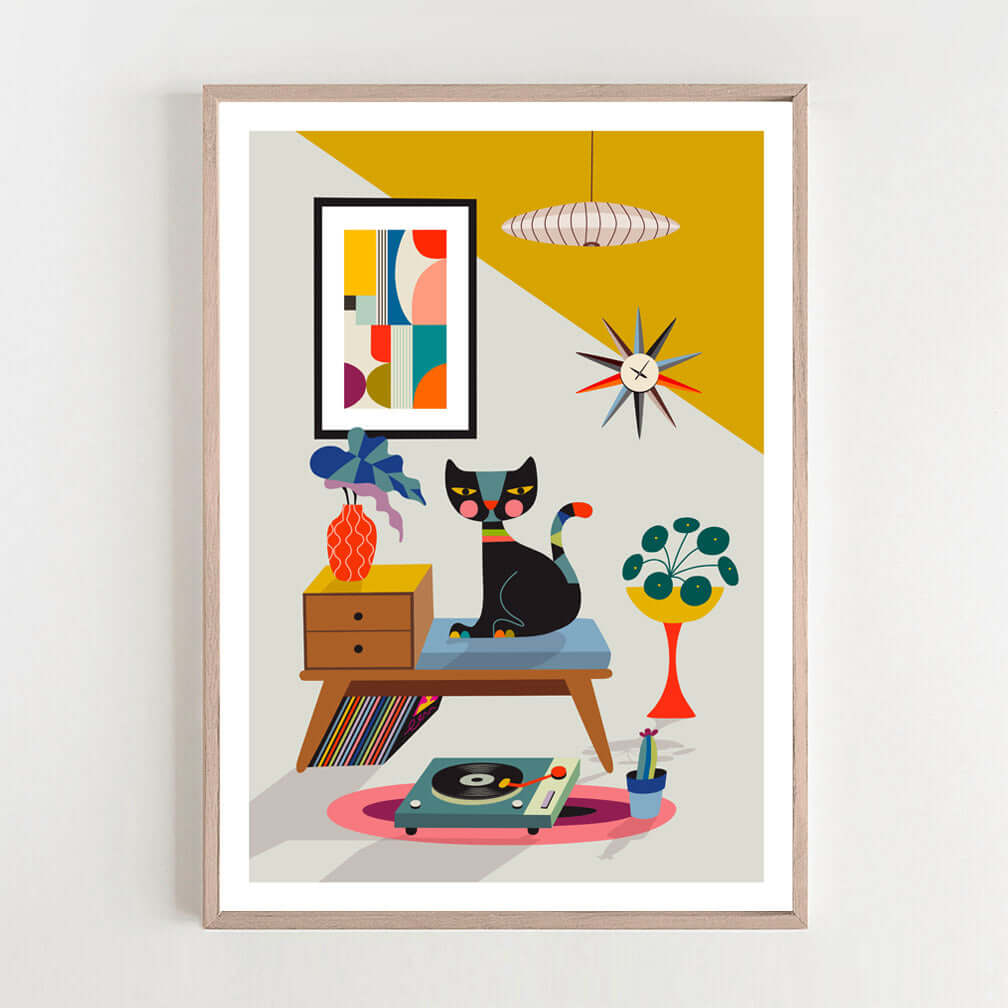 A framed art print of a cat sitting on a chair, with a record player print in the background.