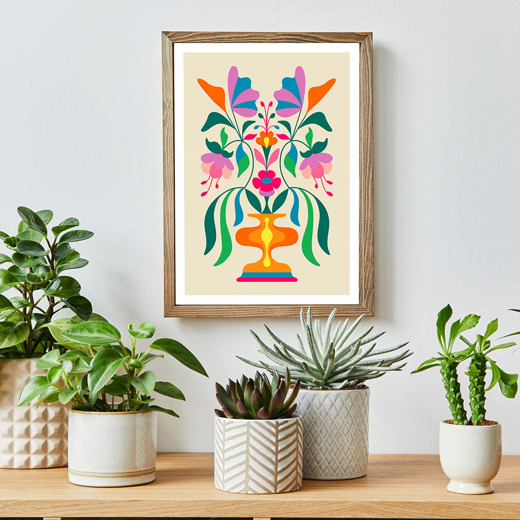Colorful floral print on wall next to potted plants.