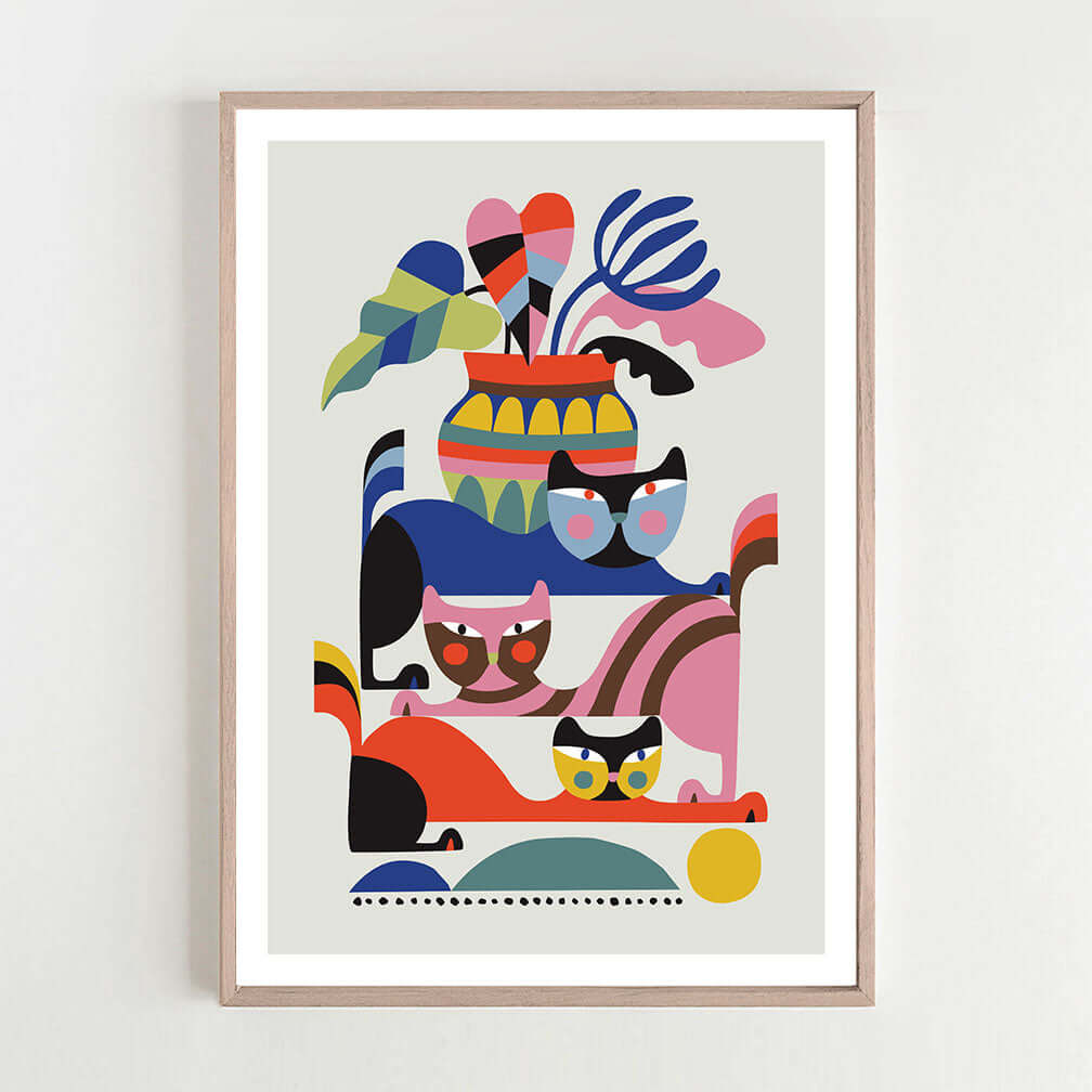 Whimsical framed print featuring cats and colorful shapes.