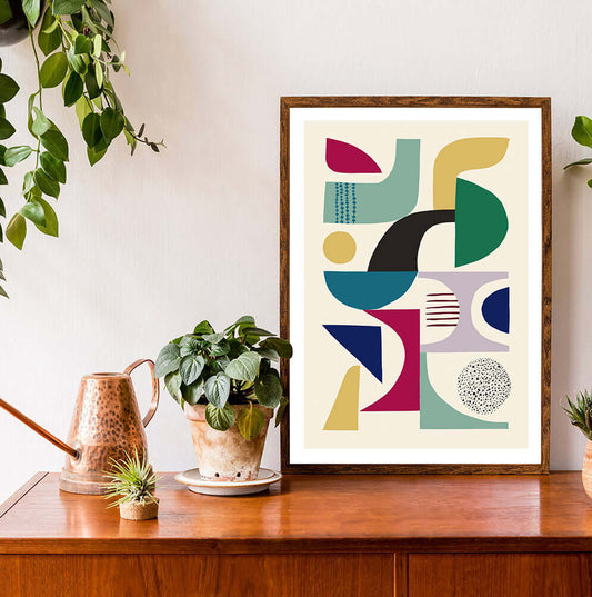 Eye-catching framed art print showcasing geometric shapes in a mid century modern design surrounded by the pot plants.