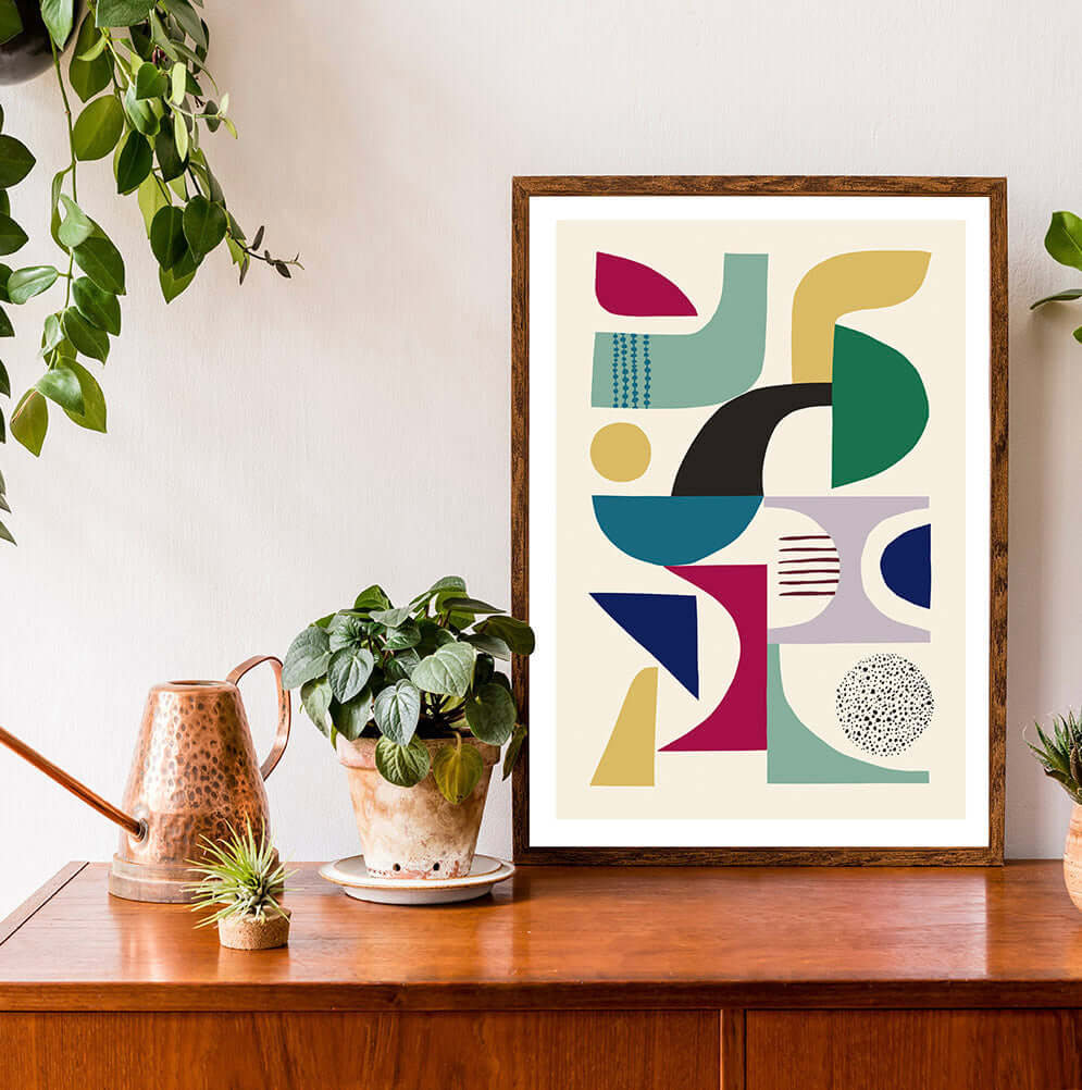 Eye-catching framed art print showcasing geometric shapes in a mid century modern design surrounded by the pot plants.