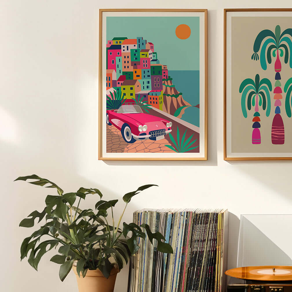 Two framed art prints hang above a record player, creating a stylish and artistic display.