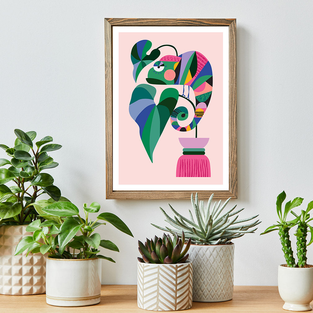 A framed art print of a plants and a chameleon.
