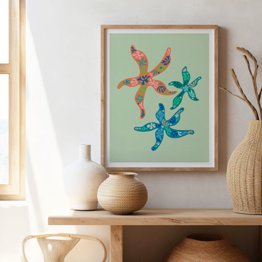 Framed art print showcasing bright flowers and leaves, with a unique starfish element, perfect for brightening up your decor.