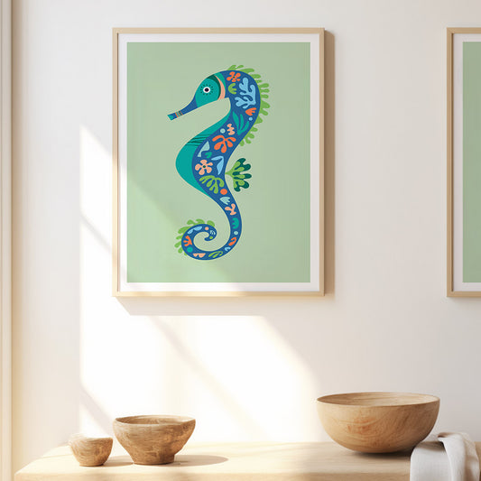 A pair of seahorse prints are framed and displayed on the wall, positioned above a stylish bowl for a coastal vibe. 