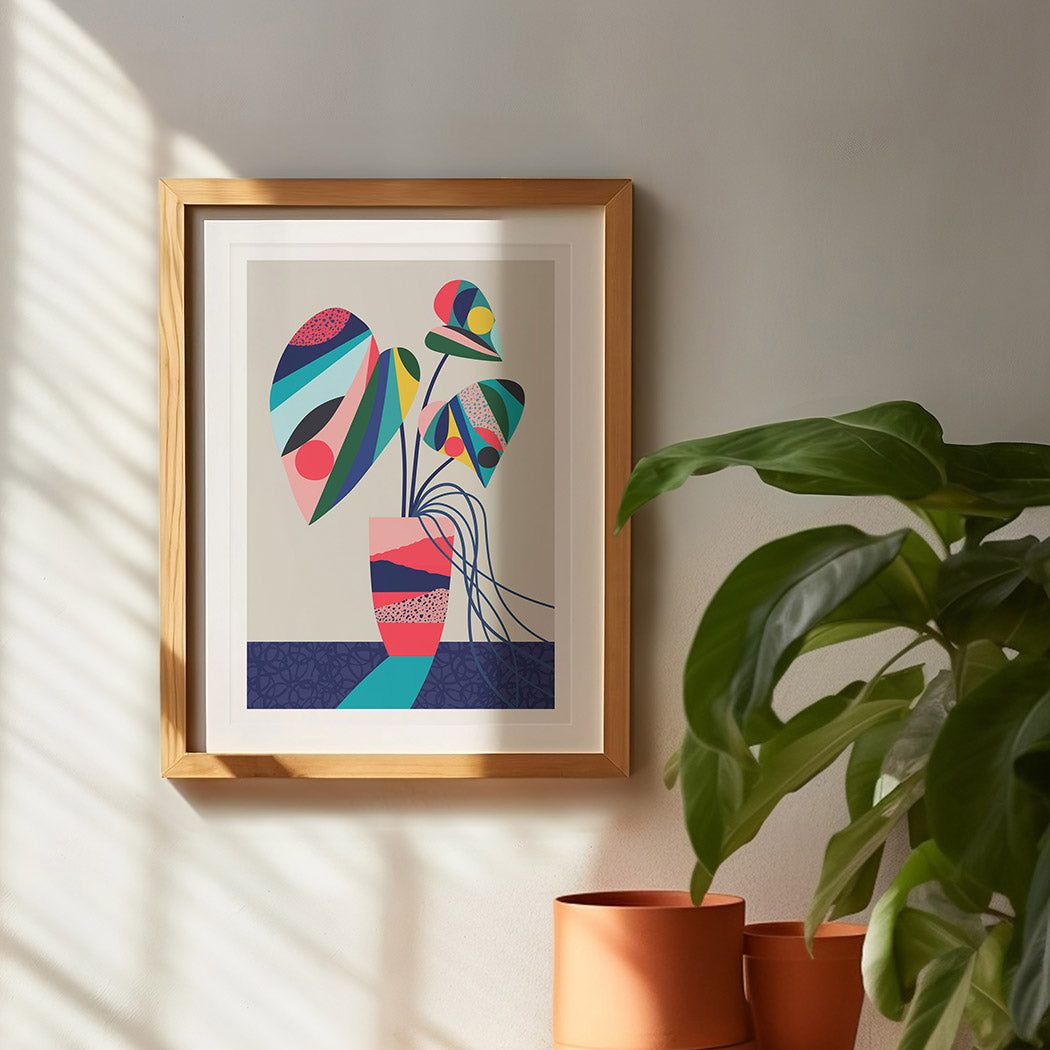 A framed art print of an abstract monstera plant in a pot on a table.