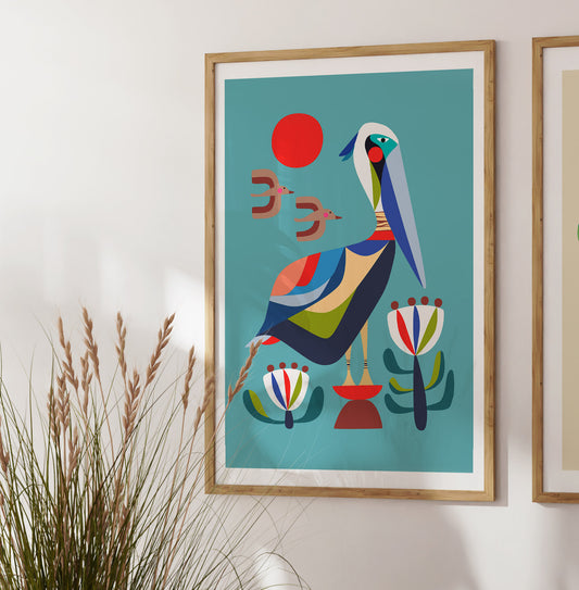 Framed abstract artwork with a colorful bird design on a teal background, mounted on a wall.