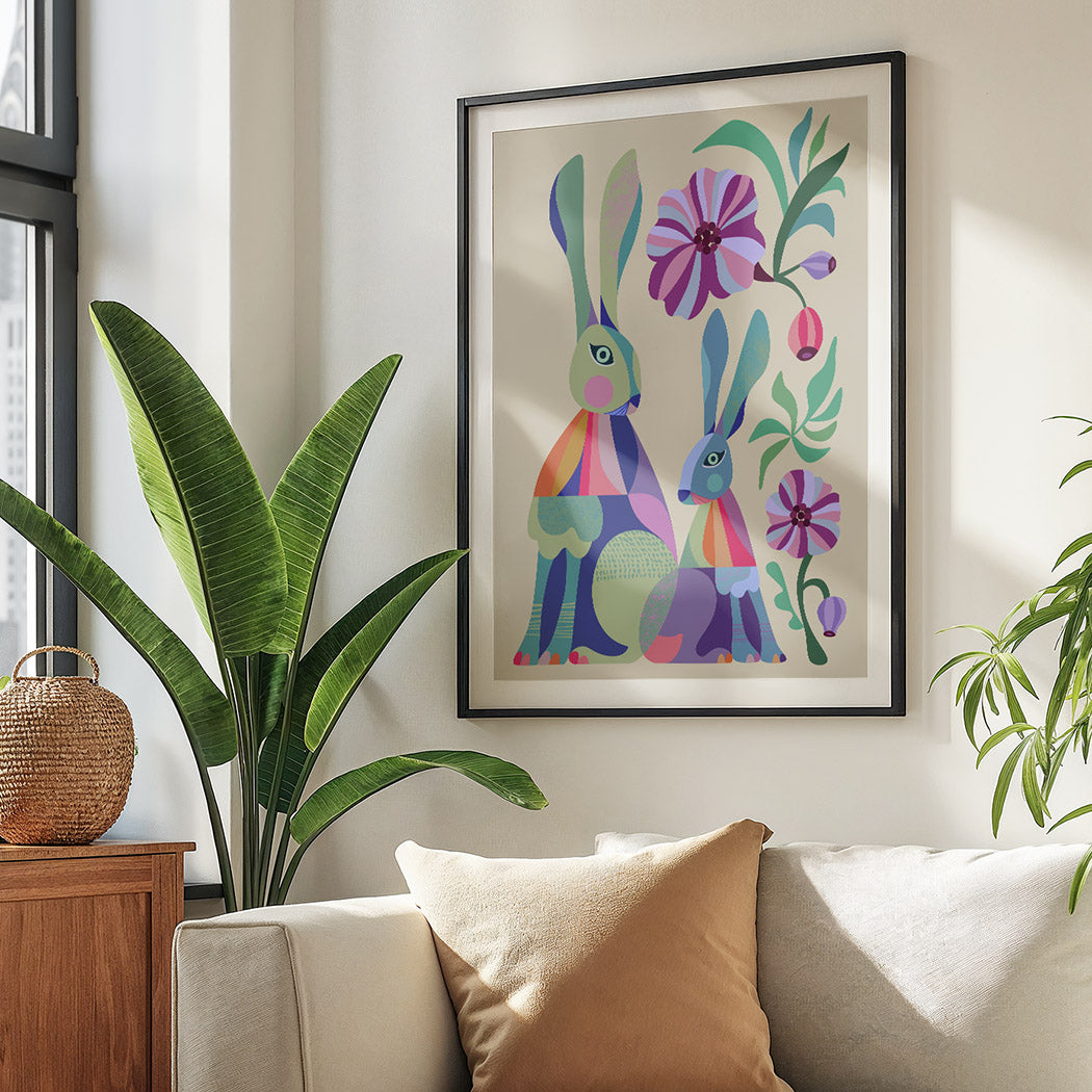 Colorful rabbit artwork on a wall above a sofa with plants around