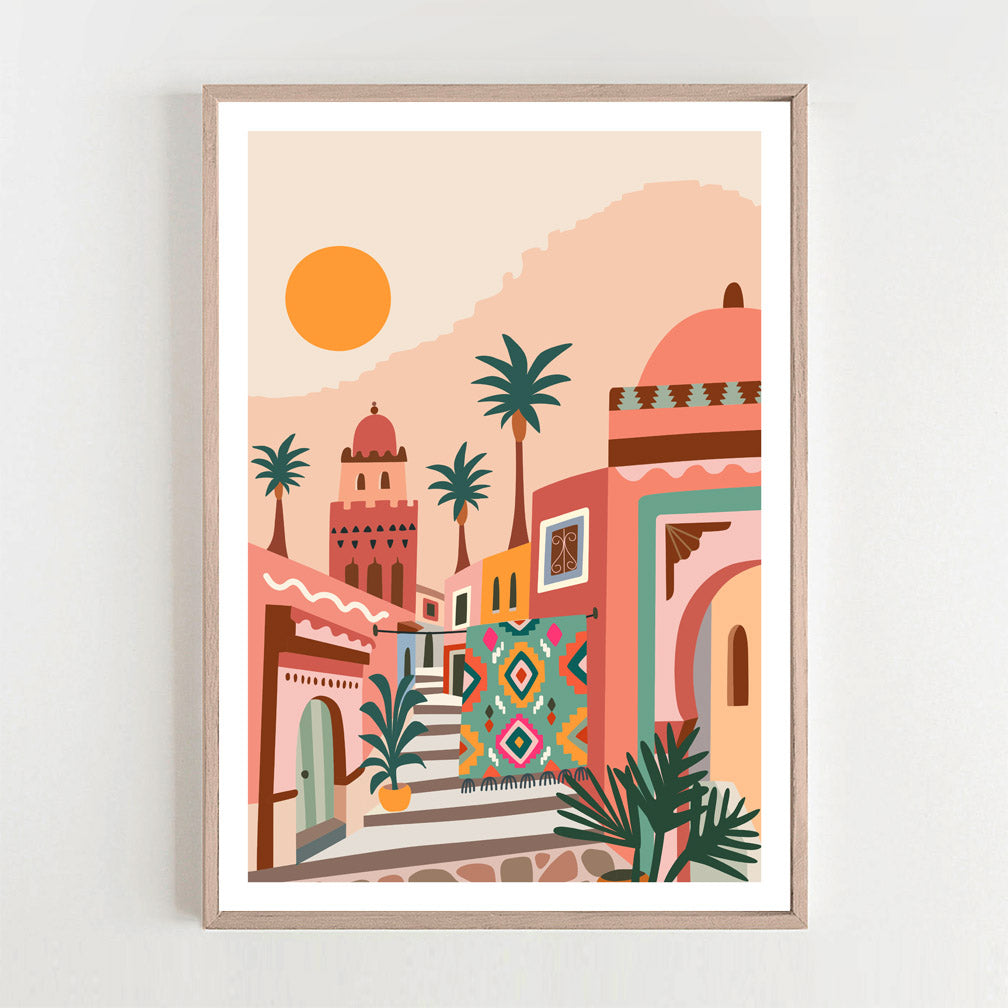 Framed print capturing the beauty of a colorful town with palm trees during a Moroccan sunset.