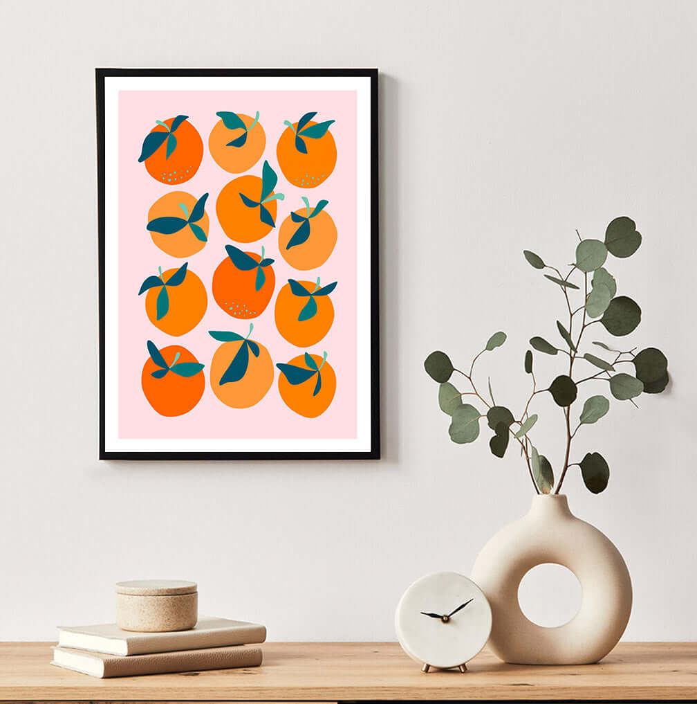 Colorful abstract art print featuring orange and pink hues hanging on a wall.