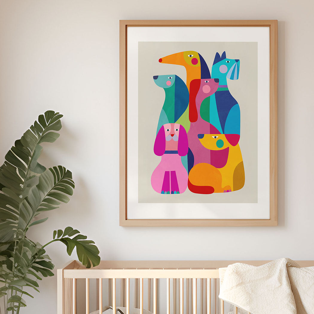 Framed colorful abstract art of dogs on a wall above a crib with a plant to the left.