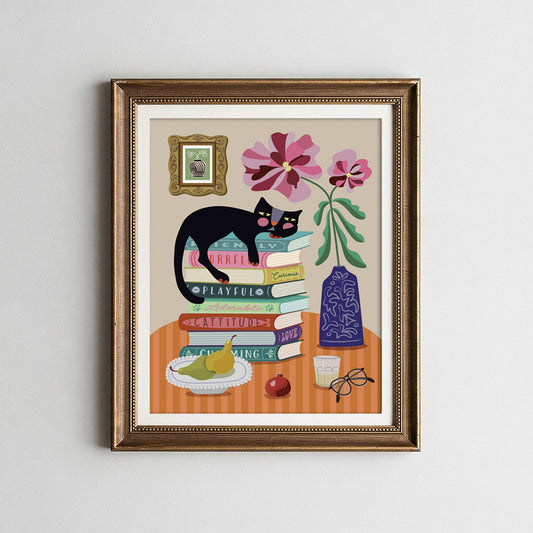 Framed artwork of a black cat on books with flowers and a vase.