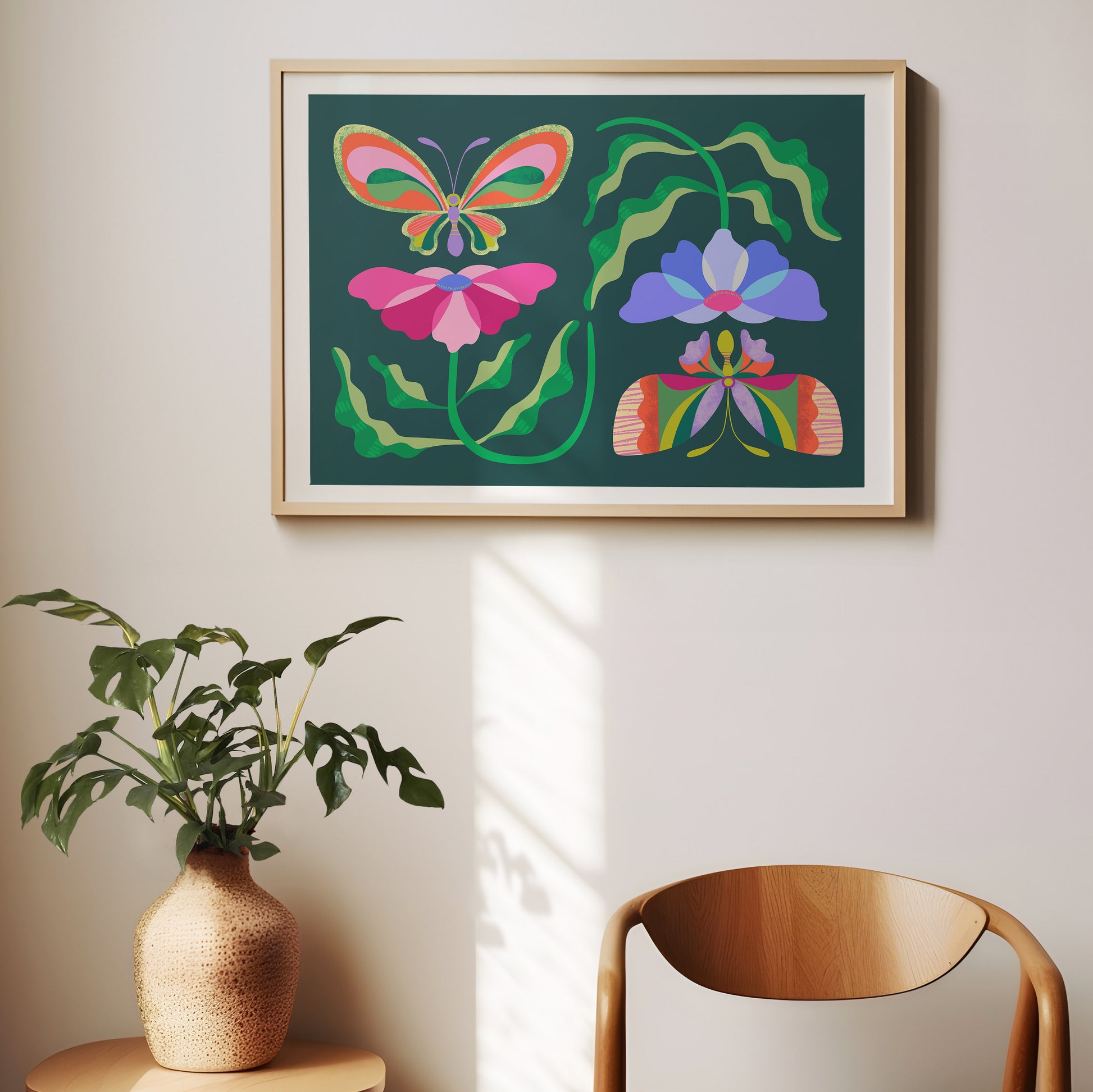 Framed colorful butterfly and flower artwork on a wall with a plant and chair in the foreground.