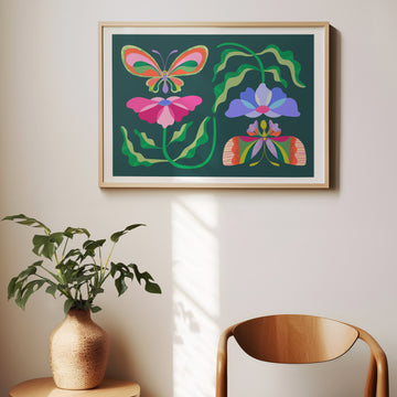 Framed colorful butterfly and flower artwork on a wall with a plant and chair in the foreground.