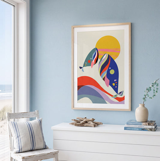 Bright coastal room with pale blue walls, ocean view, white dresser, striped chair, driftwood decor, and colorful abstract fish artwork.